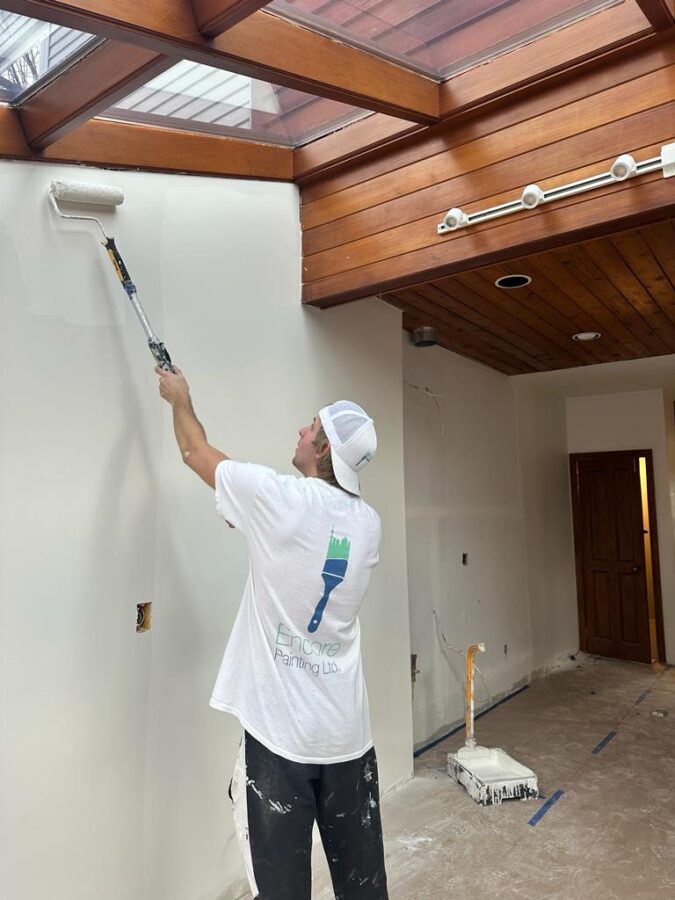 painter priming the walls before painting